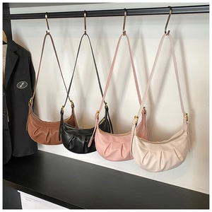 Détail de sacs hobo en forme de croissant plissés en quatre couleurs sur des crochets