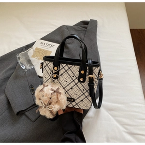 Detail of checkered bucket bag with polka dots, pearl rabbit charm and shoulder strap