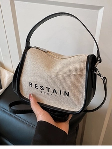 Chic beige canvas handbag with black leather trim and crossbody strap for women