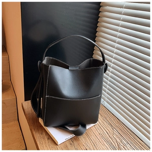 Detail of black bucket bag featuring white contrast stitching and premium leather texture