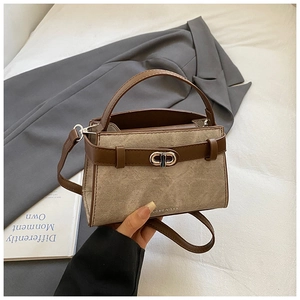 Detail showing the vintage bucket bag with silver metal swivel lock and brand logo lettering