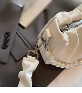 Détail du sac nuage plissé crème avec bandoulière perles et fermoir métallique argenté