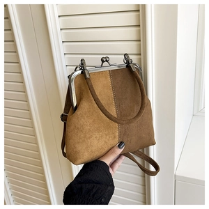 Detail of vintage suede shell bag with color-block stitching and metal frame clasp