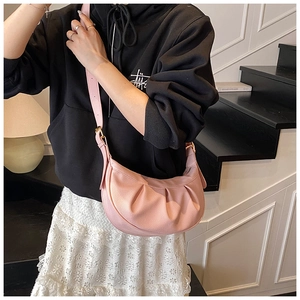 Vue détaillée du sac demi-lune plissé rose avec texture lychee et boucle dorée
