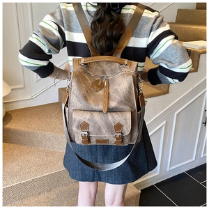 Detail view of khaki vintage canvas backpack with wide straps on a person's back