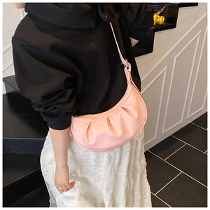 Détail du sac croissant plissé rose montrant la texture cuir et la boucle en métal doré