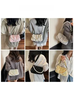 Détails rapprochés de la texture plissée et de la chaîne de perles décorative sur le sac