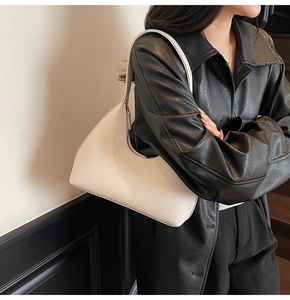 Detail of white lychee leather hobo bag worn under the arm with smooth zipper