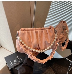 Sac nuage plissé rose avec poignée en perles élégantes et détails en cuir souple