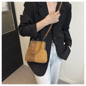 Détail du sac bandoulière vintage en daim bicolore marron et jaune avec fermoir