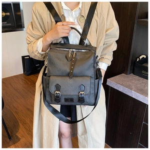 Close-up of a dark grey multi-functional backpack with silver hardware and buckles