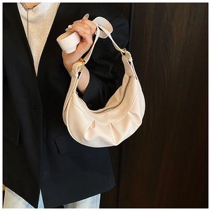 Gros plan du sac demi-lune beige en cuir grainé avec détails de fermeture éclair dorée
