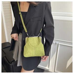 Detail of vintage green shell handbag with metal clasp and adjustable leather shoulder strap