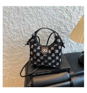 Detail of checkered denim bucket bag with fringe trim and silver metallic clasp