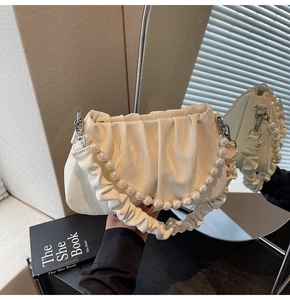 Détail du sac nuage plissé blanc cassé avec bandoulière perle et texture cuir