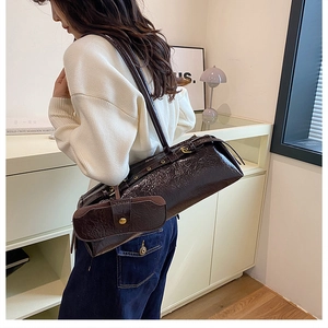 Close-up of a vintage dark brown shoulder bag in patent leather with a matching coin purse
