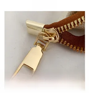 Détail de la fermeture éclair en métal doré sur le sac fourre-tout en toile beige résistant