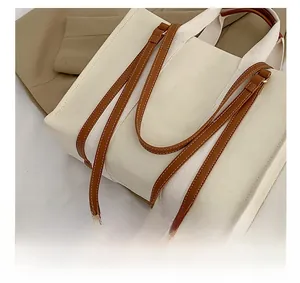 Gros plan d'un sac cabas en toile vintage avec bretelles en cuir marron et double poignée