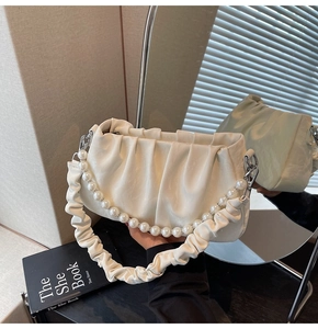 Détail du sac nuage blanc cassé avec chaîne en perles et texture en cuir plissé doux