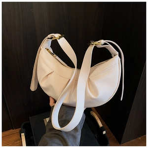 Détail du sac demi-lune blanc avec texture grainée et finitions métalliques dorées