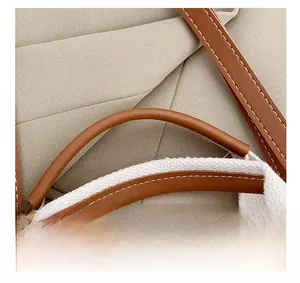Détail du sac cabas en toile montrant le tissu kaki et les coutures de l'anse en cuir brun