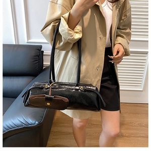 Chic black wrinkled patent leather baguette bag styled with a khaki trench coat