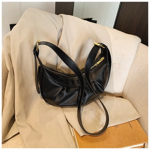Détail du sac hobo en cuir grainé noir avec fermeture éclair dorée et plis élégants raffinés