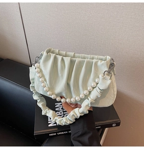 Détail du sac nuage plissé vert menthe avec une élégante anse en grosses perles