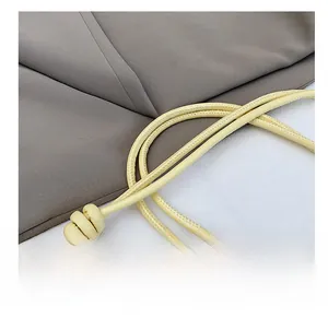 Dettaglio della tracolla in pelle PU giallo chiaro con nodi decorativi per borsa a mano