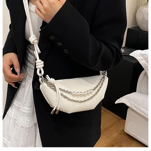 Detail of white crescent bag with woven texture, double metal chains and pearl accents