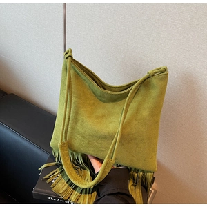 Dettaglio della borsa hobo in camoscio verde con frange lunghe e doppia tracolla