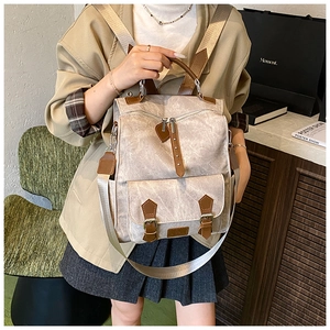 Detail of vintage canvas backpack with brown leather straps worn by model