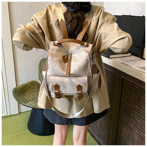 Detail of vintage gray canvas backpack with brown leather straps and metal buckle