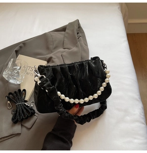 Détail du sac nuage plissé noir avec chaîne de perles et texture satinée douce et chic