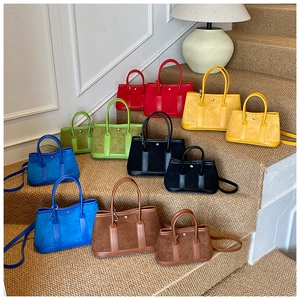 Detail view of suede contrast tote bags in various sizes and colors on a staircase
