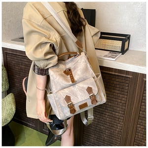 Detailed view of the vintage beige canvas backpack with premium brown leather straps and accents