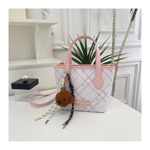 Pink checkered bucket bag featuring gold brand plaque and brown puppy charm detail
