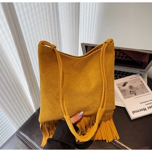 Dettaglio della borsa tote in pelle scamosciata gialla con frange e stile bohémien