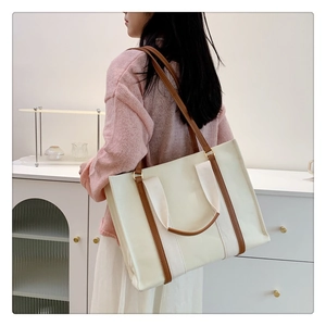 Mannequin portant un grand sac cabas en toile avec garniture en cuir brun et bandoulière