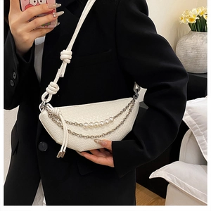 Détail du sac croissant tressé blanc avec chaînes à perles et bandoulière à nœuds
