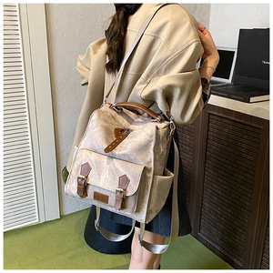 Side view of a vintage beige canvas backpack with brown straps in a cozy lifestyle setting