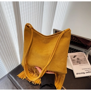 Dettaglio borsa tote in pelle scamosciata gialla con lunghe frange e doppi manici sottili