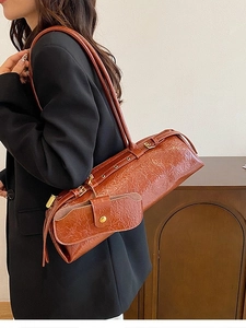 Brown retro pleated cylinder shoulder bag with a mini pouch charm on model