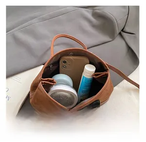Top view of spacious brown matte tote bag interior with zip pocket and daily essentials