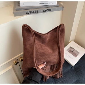 Dettaglio della borsa tote in pelle scamosciata marrone con frange e manico in pelle