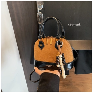 Detail of vintage shell bag with brown suede and black quilted leather with wood beads