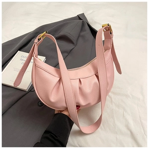 Détail du sac dumpling en cuir rose avec plis souples et boucle en métal doré chic