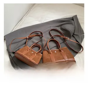 Detail of caramel brown suede and leather bucket bag on a professional grey suit