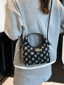 Checkered denim bucket bag with plush texture and leather handle shown on model