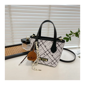 Detail of white quilted bucket bag with polka dots, bear charm and COIH 2DN label